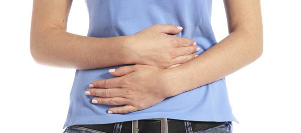 alt: Một cốc sữa chua và các loại trái cây tươi như việt quất, dâu tây, chuối được đặt trên một chiếc khăn ăn màu xanh nhạt.